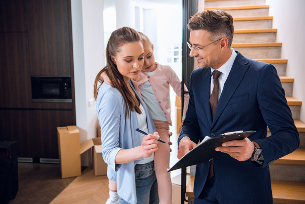 stock photo attractive woman holding arms daughter signing document handsome broker holding