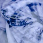 from above of dyed cloth with abstract blue and white pattern in water